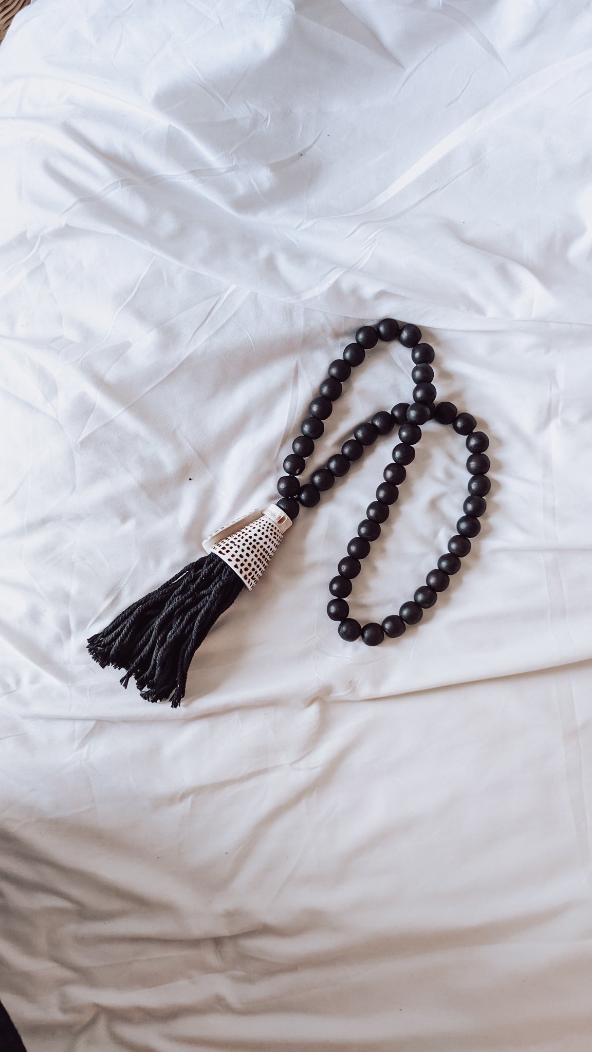 BLACK WOODEN DECOR WITH SHELL TASSEL
