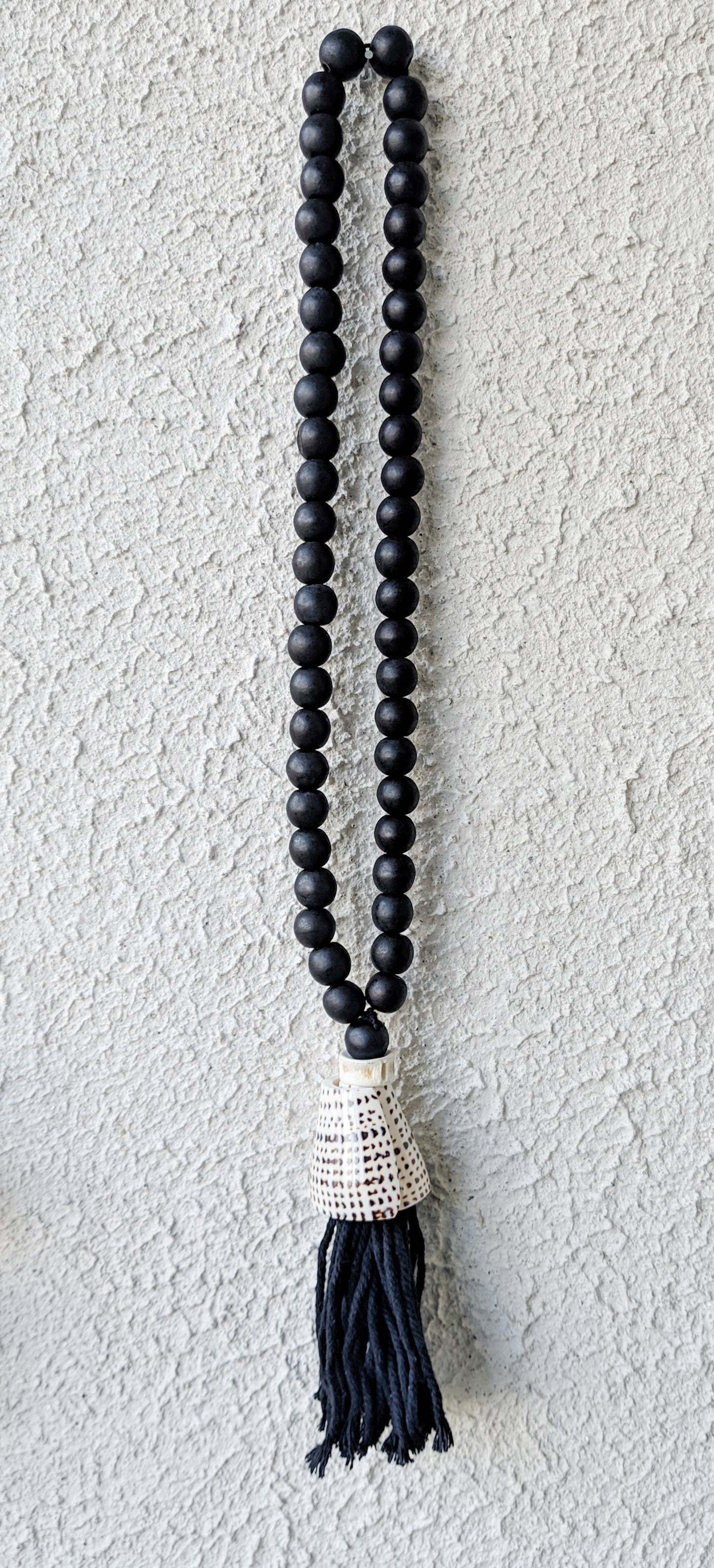 BLACK WOODEN DECOR WITH SHELL TASSEL